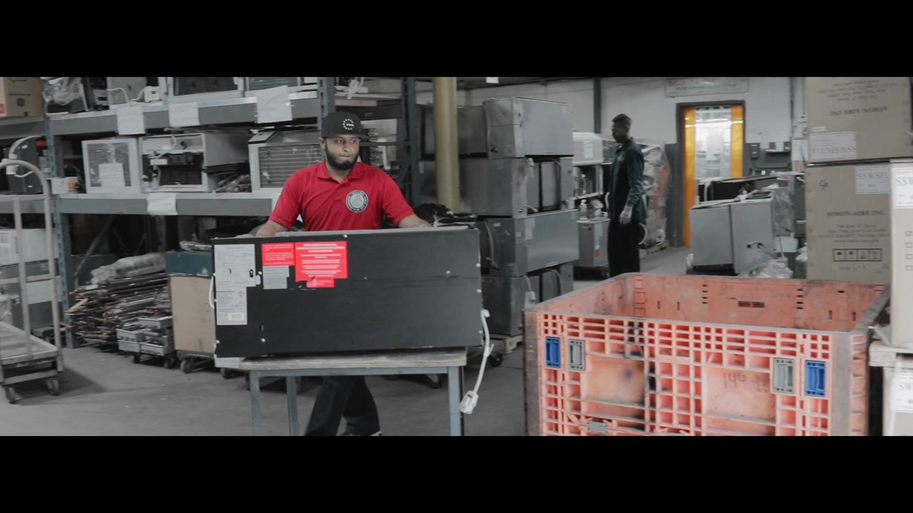 Figlia and Sons technician moving a PTAC unit through the repair shop